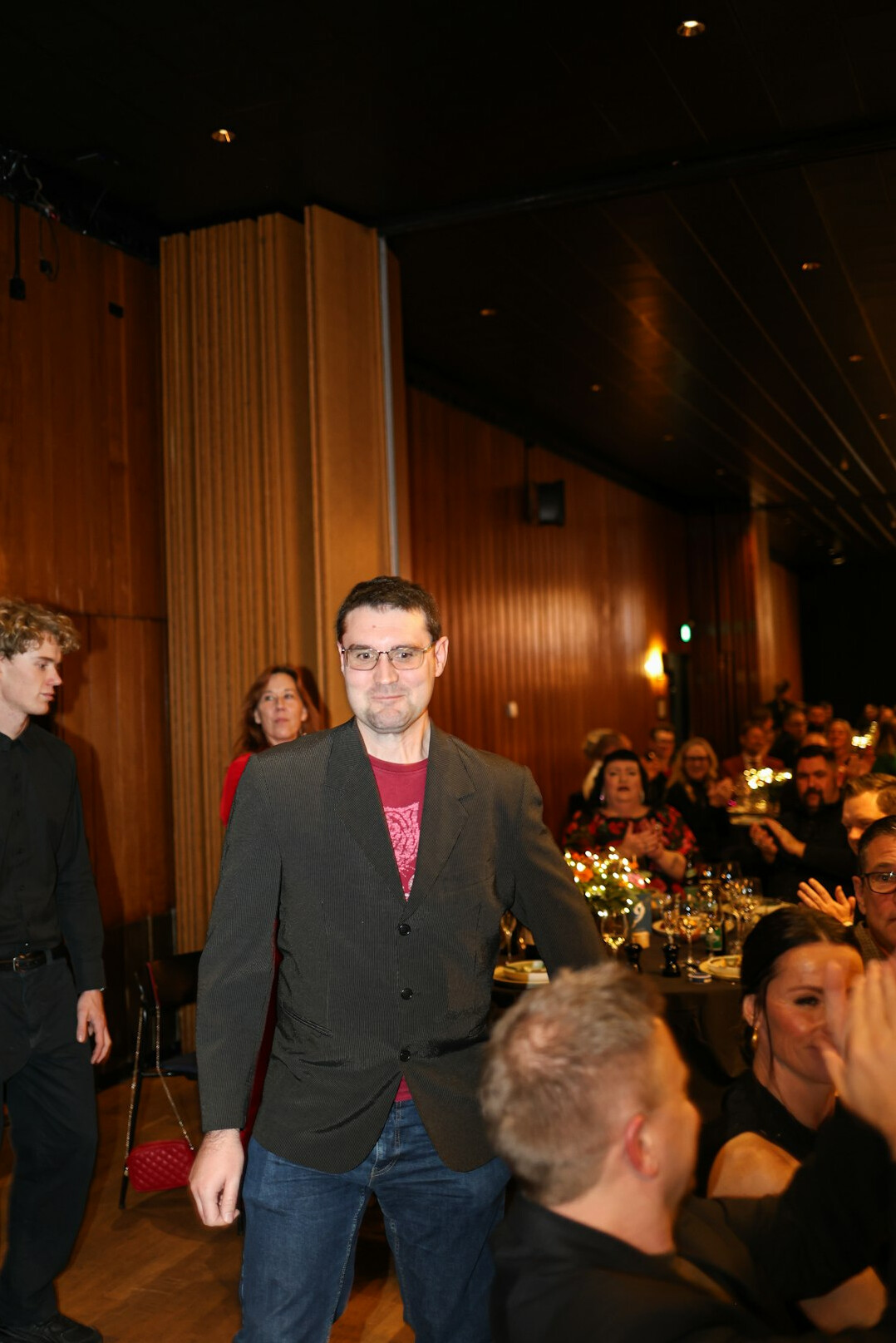 Swiss television moderator in a formal blazer smiling at the camera