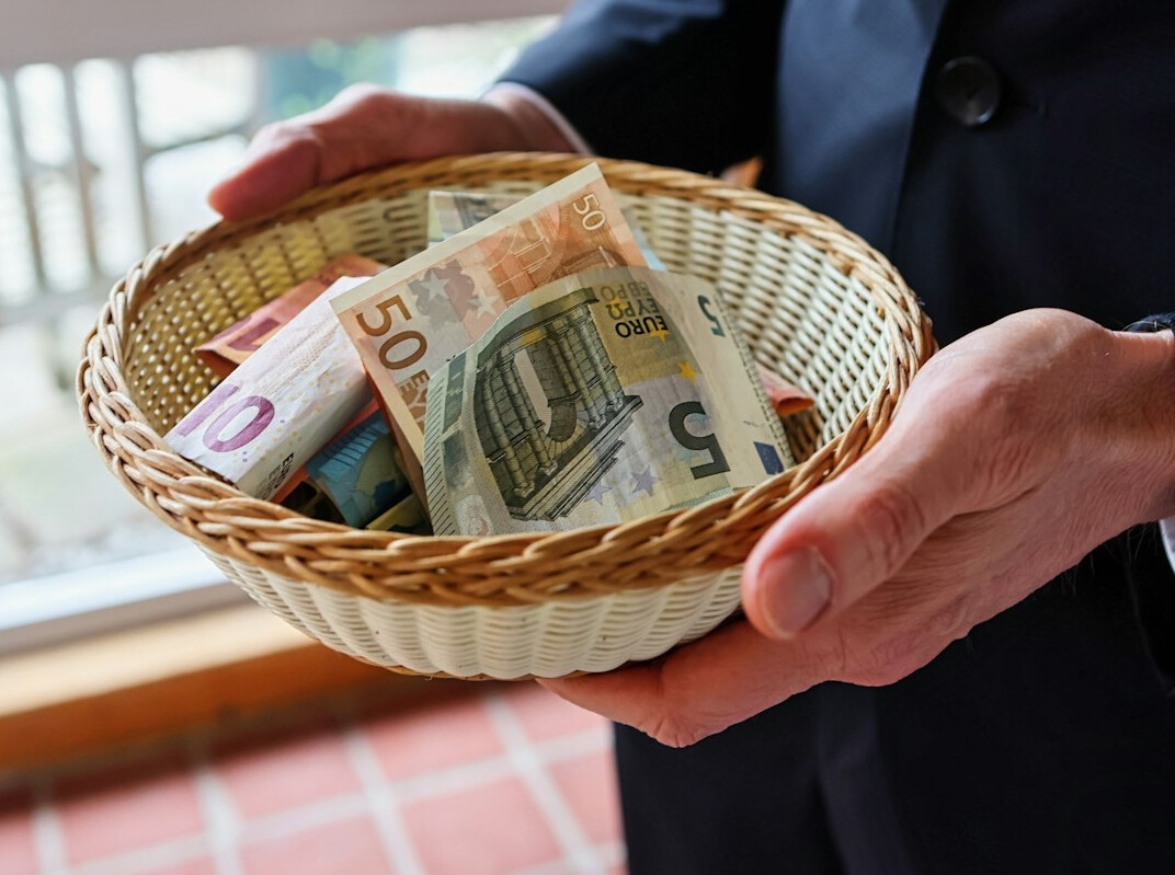 German television journalist in a suit holding notes